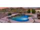 Inviting pool with waterfall features and desert landscaping, perfect for relaxing and enjoying the desert scenery at 17562 W Desert Sage Dr, Goodyear, AZ 85338