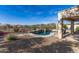 Private backyard with a sparkling pool featuring cascading waterfalls and beautiful desert surroundings at 17562 W Desert Sage Dr, Goodyear, AZ 85338