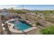 Backyard pool with waterfall feature, desert landscape, and lounge chairs at 17562 W Desert Sage Dr, Goodyear, AZ 85338