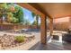 Outdoor covered patio leads to a serene backyard with mature trees and pond feature at 17851 W Calavar Rd, Surprise, AZ 85388