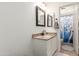 Bathroom featuring a vanity with a granite countertop, decorative mirror, and shower with curtain at 17851 W Calavar Rd, Surprise, AZ 85388
