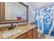Bathroom featuring a granite countertop, wooden cabinet, and shower with patterned curtain at 17851 W Calavar Rd, Surprise, AZ 85388