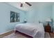 Comfortable bedroom featuring a ceiling fan, plush bedding and a window view at 17851 W Calavar Rd, Surprise, AZ 85388