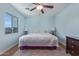 Bright bedroom features a ceiling fan, plush bedding and a view from the window at 17851 W Calavar Rd, Surprise, AZ 85388