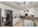 Open concept kitchen with stainless-steel appliances and view to living area and staircase at 17851 W Calavar Rd, Surprise, AZ 85388