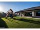 Spacious backyard with artificial turf, a playset, and lush green surroundings at 18125 W Montebello Ct # 67, Litchfield Park, AZ 85340