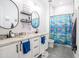 Kid-friendly bathroom featuring dual sinks, bright blue accents, and a playful shower curtain creating a functional space at 18125 W Montebello Ct # 67, Litchfield Park, AZ 85340