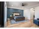 Comfortable bedroom with a striking blue accent wall and wood flooring at 18125 W Montebello Ct # 67, Litchfield Park, AZ 85340