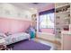 Cute bedroom with pink walls, soft carpet, and built-in bookshelves offering a delightful and inviting space at 18125 W Montebello Ct # 67, Litchfield Park, AZ 85340