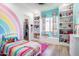 Bright bedroom featuring a rainbow wall design and built-in shelving filled with stuffed animals at 18125 W Montebello Ct # 67, Litchfield Park, AZ 85340