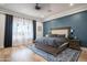 Inviting bedroom with large windows, blue accent wall, and an elegant bed at 18125 W Montebello Ct # 67, Litchfield Park, AZ 85340