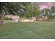 Large backyard featuring a lush green lawn, mature shade trees, and ample space for outdoor entertaining at 1886 S 141St Pl, Gilbert, AZ 85295