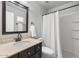 This bathroom features a marble countertop, dark wood cabinets, and a shower with white tile at 1886 S 141St Pl, Gilbert, AZ 85295