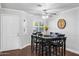 Cozy dining room featuring hardwood floors, wainscoting, and a modern ceiling fan above a dark wood table with six chairs at 1886 S 141St Pl, Gilbert, AZ 85295