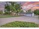 Expansive property featuring a well-maintained lawn, mature trees, and a long driveway leading to an attached garage at 1886 S 141St Pl, Gilbert, AZ 85295