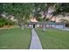 Quaint home showcasing a verdant lawn, mature trees, and a welcoming front porch with rocking chairs at 1886 S 141St Pl, Gilbert, AZ 85295