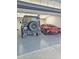 Well-lit garage featuring epoxy floor and two luxury vehicles at 1886 S 141St Pl, Gilbert, AZ 85295