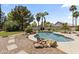 Beautiful backyard featuring a rock water feature, lush landscaping, and a refreshing pool at 19010 N 35Th Way, Phoenix, AZ 85050
