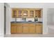 Elegant bar area with wood cabinetry and a view overlooking the outdoor pool area at 19010 N 35Th Way, Phoenix, AZ 85050