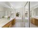 Bathroom with dual sinks, mirrored closet, garden tub, and bright natural light at 19010 N 35Th Way, Phoenix, AZ 85050