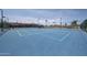 Bright blue community tennis court surrounded by fencing and mature palm trees at 1920 E Westchester Dr, Chandler, AZ 85249