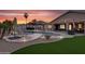 Gorgeous backyard with a pool, hot tub, outdoor seating, manicured landscaping, and a stunning sunset view at 19903 E Augustus Ave, Queen Creek, AZ 85142