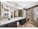 Elegant bathroom featuring dual sinks, tile floors, vanity lighting, and a tiled walk-in shower at 19903 E Augustus Ave, Queen Creek, AZ 85142