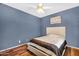 Bedroom with hardwood floors, ceiling fan, window with blinds and a blue accent wall at 19903 E Augustus Ave, Queen Creek, AZ 85142