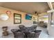 Outdoor covered patio with dining table, mounted television, ceiling fan, and stone grill at 19903 E Augustus Ave, Queen Creek, AZ 85142