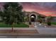 Beautiful home with mature tree, desert landscaping, manicured lawn and warm outdoor lighting at 19903 E Augustus Ave, Queen Creek, AZ 85142
