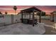 Outdoor covered hot tub on stone patio with privacy wall, planters, and sunset views at 19903 E Augustus Ave, Queen Creek, AZ 85142