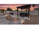 Backyard with a hot tub, swing, gravel landscaping, and solar lighting, perfect for relaxing under a vibrant sunset at 19903 E Augustus Ave, Queen Creek, AZ 85142