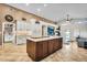 Open-concept kitchen showcasing a large island, custom cabinets, and seamless flow into the living area at 19903 E Augustus Ave, Queen Creek, AZ 85142