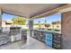 Covered outdoor kitchen with stone counters, built-in grill, and bar seating with outdoor views at 19903 E Augustus Ave, Queen Creek, AZ 85142