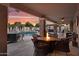 Inviting outdoor space with a fire pit, comfortable seating, pool, and hot tub, all set against a vibrant sunset at 19903 E Augustus Ave, Queen Creek, AZ 85142