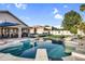 Backyard pool and spa with a diving board, artificial turf, and covered patio area at 19903 E Augustus Ave, Queen Creek, AZ 85142