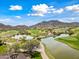 Overhead view of a golf course community, featuring ponds and mountain views at 20453 W Daniel Pl, Buckeye, AZ 85396