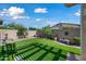 Well-manicured backyard featuring lush artificial turf, privacy walls, and colorful landscaping at 20453 W Daniel Pl, Buckeye, AZ 85396