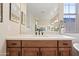 Bathroom vanity with wood cabinets and a white countertop, reflecting in a large mirror at 20453 W Daniel Pl, Buckeye, AZ 85396
