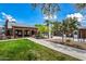 Brick clubhouse features an open picnic area and well-maintained landscaping with grassy area, walkway, and trees at 20453 W Daniel Pl, Buckeye, AZ 85396