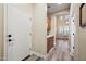 Hallway with wood cabinets and quartz counter, leading to a living room with plank flooring at 20453 W Daniel Pl, Buckeye, AZ 85396
