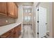 Hallway with wood cabinets, gray backsplash, and plank flooring leading to a living room at 20453 W Daniel Pl, Buckeye, AZ 85396