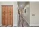 Long hallway with gray wood floors and built in cabinets, leading to front door at 20453 W Daniel Pl, Buckeye, AZ 85396