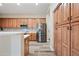 Bright kitchen with wood cabinets, stainless steel refrigerator, and pantry with plank flooring at 20453 W Daniel Pl, Buckeye, AZ 85396