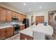 Modern kitchen features wooden cabinetry, stainless steel appliances, quartz countertops, and gray tile backsplash at 20453 W Daniel Pl, Buckeye, AZ 85396