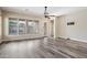 Open-concept living room with wood floors, ceiling fan, and large windows at 20453 W Daniel Pl, Buckeye, AZ 85396