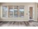 Living room featuring three windows, wood floors, and an exterior door with a glass window at 20453 W Daniel Pl, Buckeye, AZ 85396
