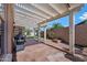 The covered patio includes a barbecue and view of the grassy backyard at 20453 W Daniel Pl, Buckeye, AZ 85396