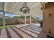 Beautiful covered patio with lighting, landscaping, and a charming fountain for relaxing outdoor enjoyment at 20453 W Daniel Pl, Buckeye, AZ 85396