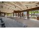 Spacious picnic area featuring ample seating with tables, brick pillars, and a high ceiling with exposed beams and fans at 20453 W Daniel Pl, Buckeye, AZ 85396